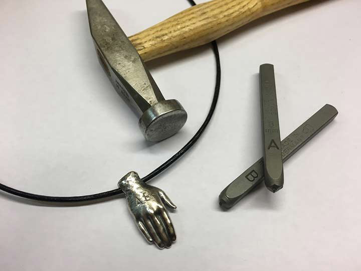 Talisman in Form einer schützenden Hand mit handgepunzten Initialen
